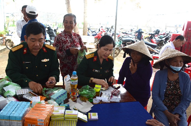 Military medical doctors give health examination and treatment to people in flood areas in Quang Ngai